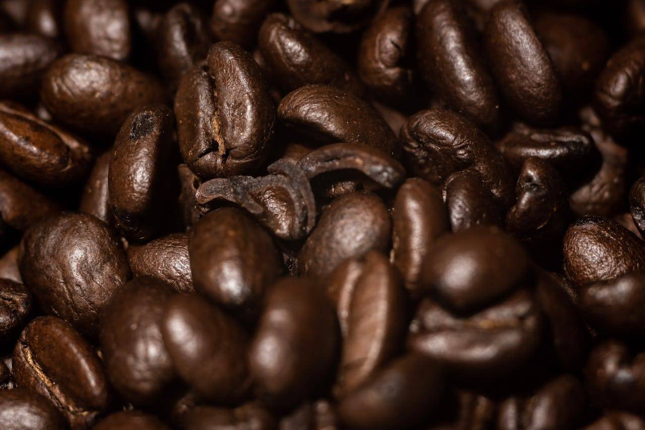 Detailed close-up of aromatic roasted coffee beans, capturing rich textures and deep brown hues.